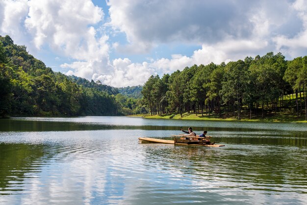 People on a boat on a lake with trees