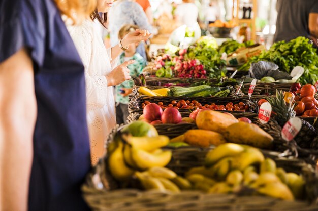 La gente che compra verdura sulla stalla al mercato