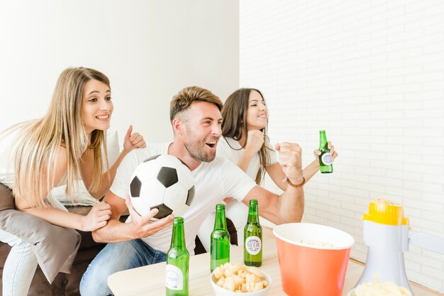 People celebrating goal watching football on sofa