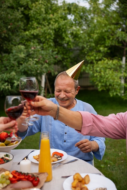 People celebrating a senior birthday party outdoors in the garden