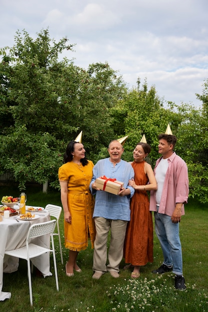 People celebrating a senior birthday party outdoors in the garden