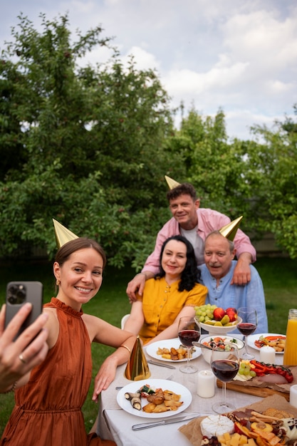 高齢者の誕生日パーティーを庭で屋外で祝う人々