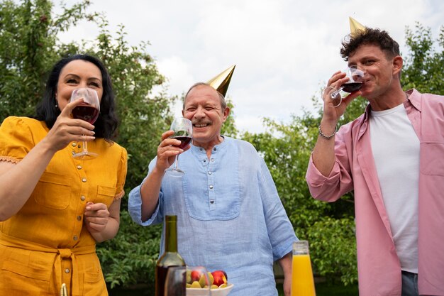 People celebrating a senior birthday party outdoors in the garden