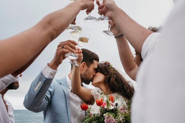 ビーチで結婚する友達と祝う人々