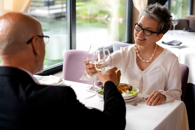 Free photo people cheering with wine glasses at a luxurious restaurant