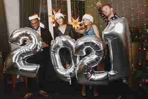 Free photo people in a christman decorations. man in a black suit. group celebrations new year. people with ballons 2021.