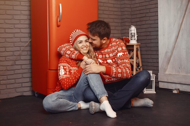 크리스마스 장식에있는 사람들. 빨간 스웨터에 남자와 여자.