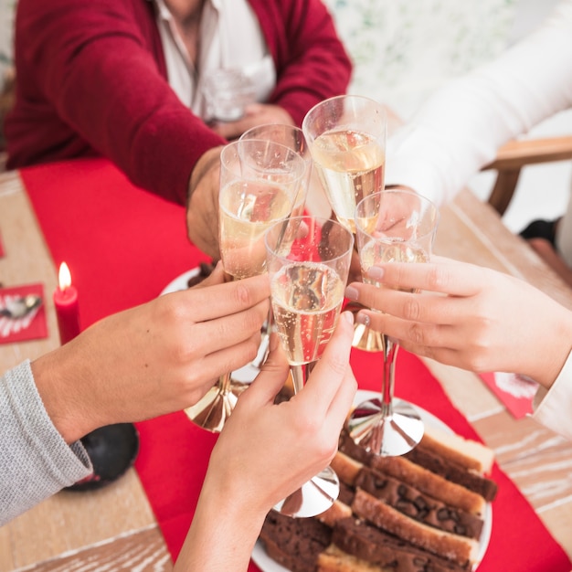 People clanging glasses of champagne at festive table