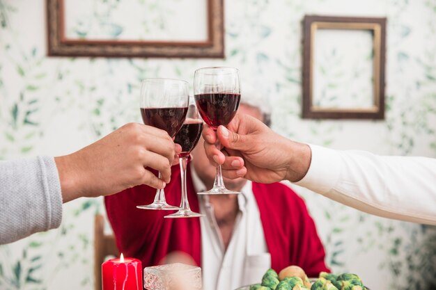 People clanging glasses at festive table 