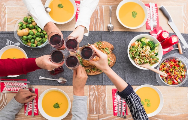 People clanging glasses above festive table