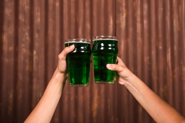 Люди звенят стаканами зеленого напитка