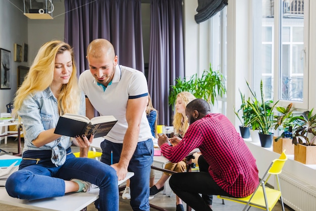 Foto gratuita persone nel libro di lettura in classe