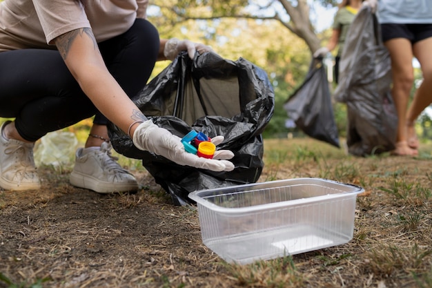 Free photo people cleaning garbage from nature