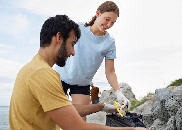 Free photo people cleaning garbage from nature