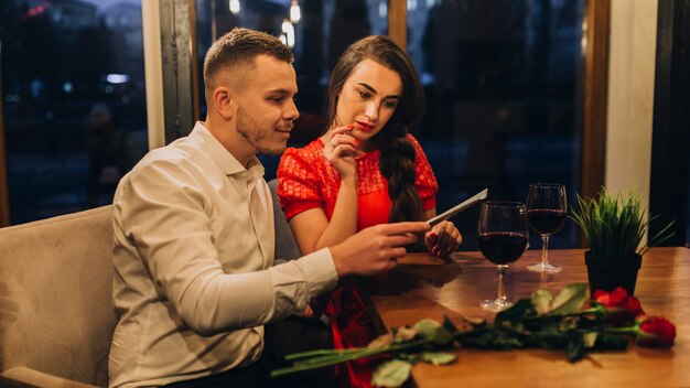 People on date in restaurant reading menu