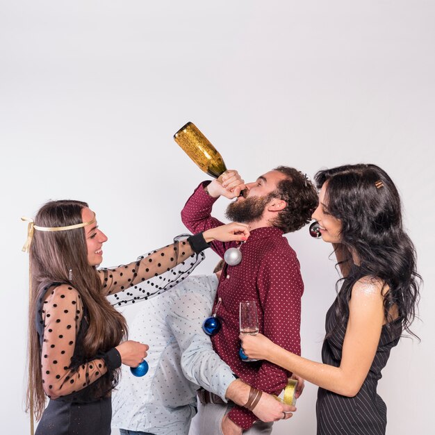 People decorating man with baubles while he drinking 