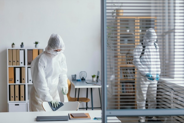 Foto gratuita persone che disinfettano un'area a rischio biologico