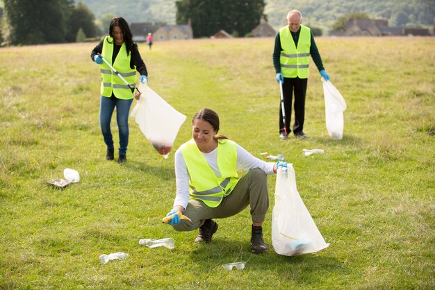 People doing community service by collecting trash outdoors