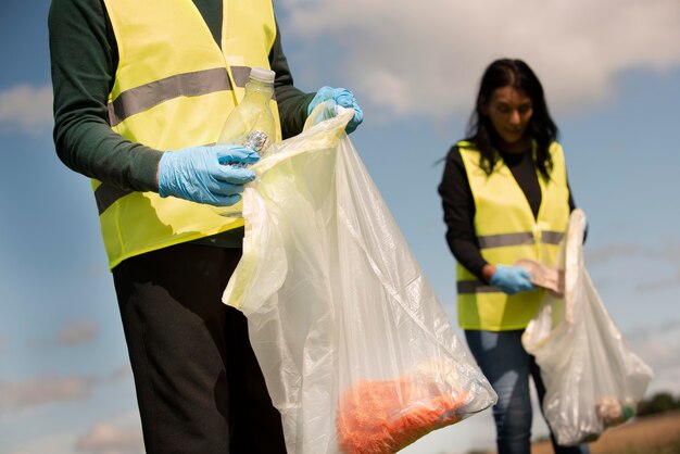Люди выполняют общественные работы, собирая мусор на открытом воздухе
