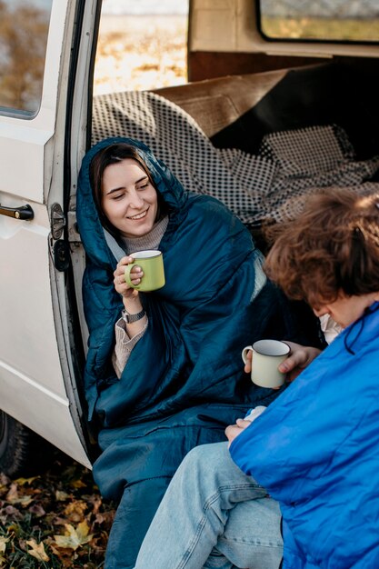 People drinking coffee inside their van