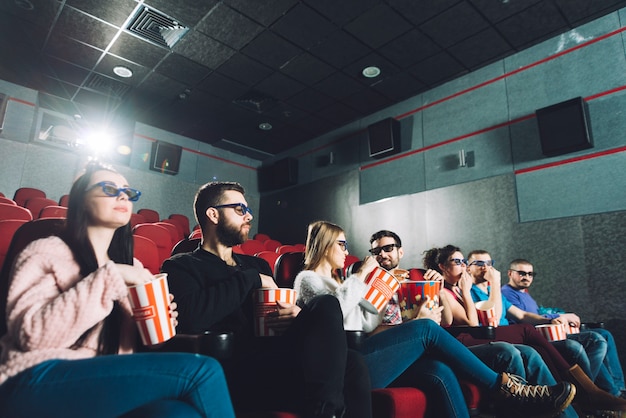 Foto gratuita persone che mangiano popcorn e guardano film