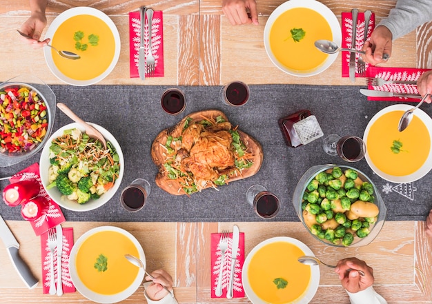 People eating soup at festive table 