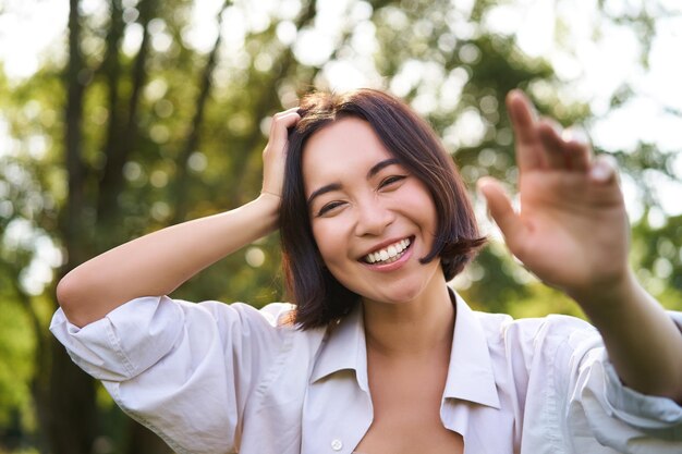 人々 と感情の概念幸せなアジア女性笑って、公園で夏の日にポーズをとって笑顔