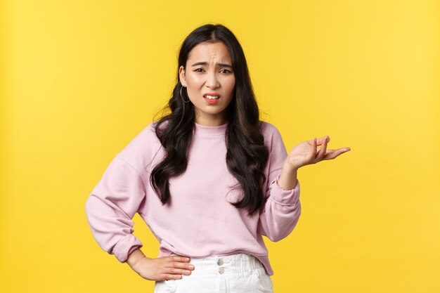People emotions, lifestyle and fashion concept. Confused and unimpressed korean girl in stylish outfit, arguing, having conversation, shrugging with hand raised in dismay, look skeptical