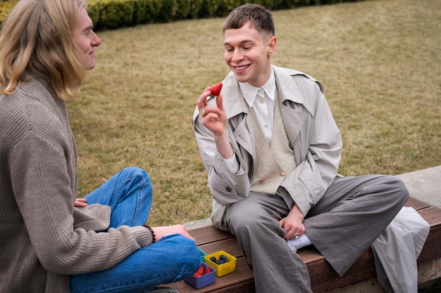 Free photo people enjoying a berry snack outdoors