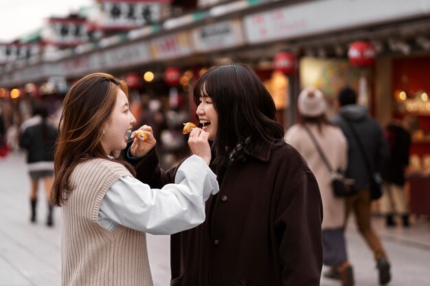 日本の屋台の食べ物を楽しむ人々