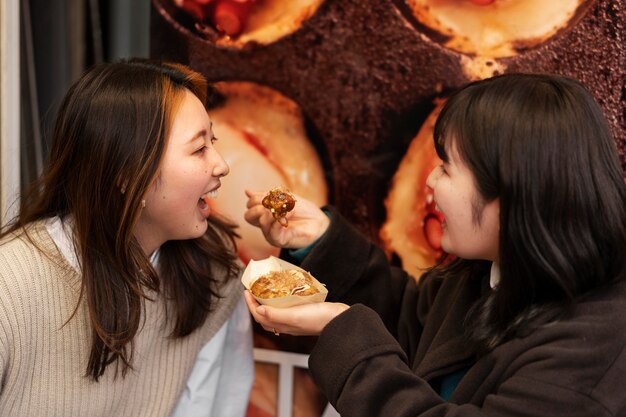 日本の屋台の食べ物を楽しむ人々