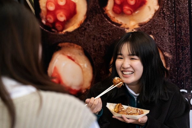 日本の屋台の食べ物を楽しむ人々