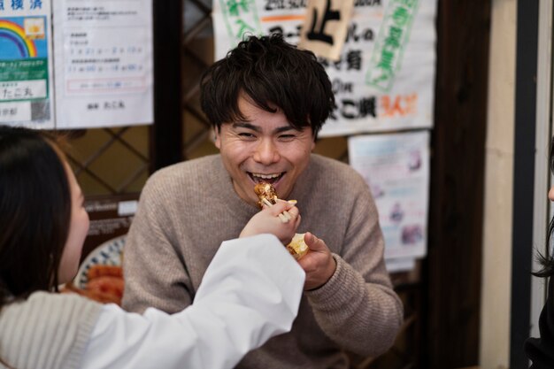 日本の屋台の食べ物を楽しむ人々