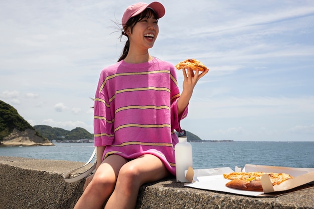 Foto gratuita le persone che si godono uno spuntino pizza all'aperto