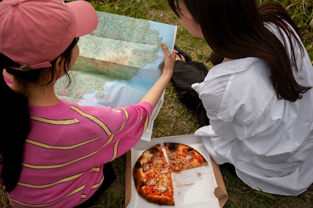 People enjoying pizza together outdoors