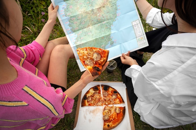 People enjoying pizza together outdoors