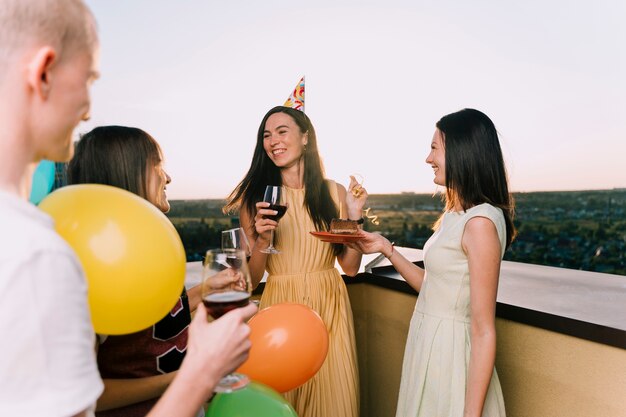 People enjoying wine and cake on the rooftop