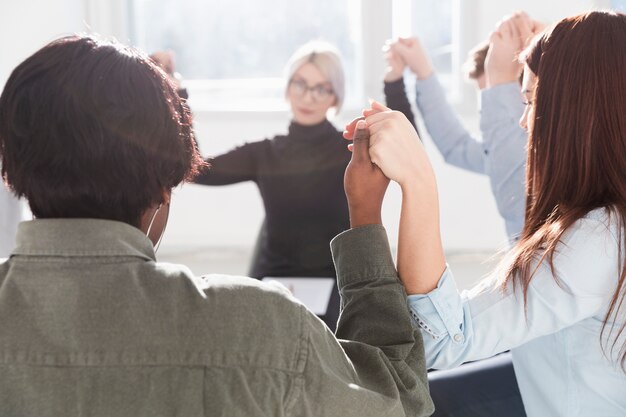 People forming a circle and raising hands