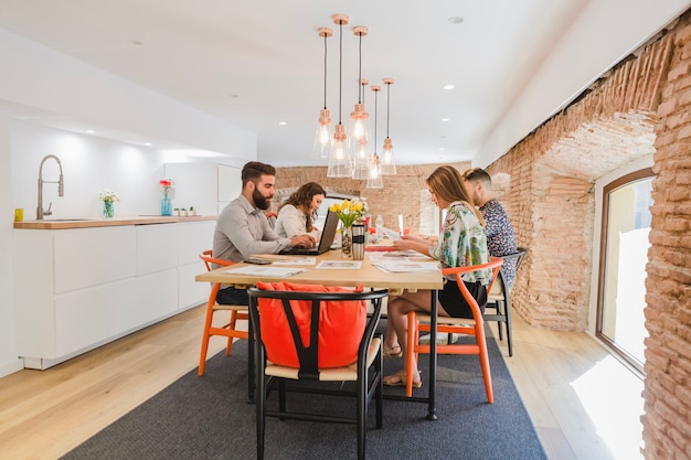 People gathering at table in stylish office