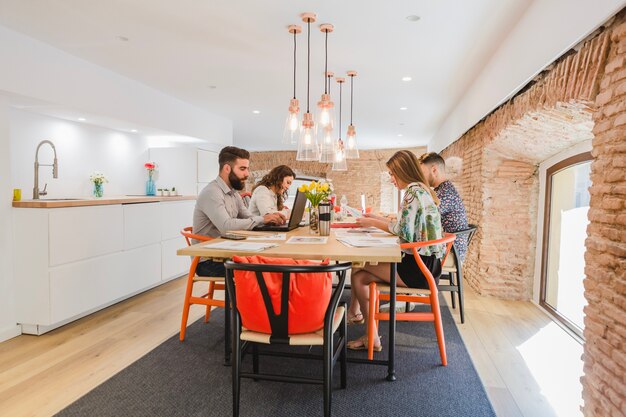 People gathering at table in stylish office