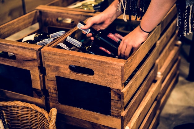 Foto gratuita mani di persone che ottengono una bottiglia di vino rosso