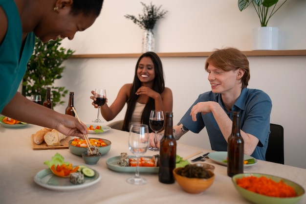 ディナーパーティーで食べ物や飲み物を楽しむ人々