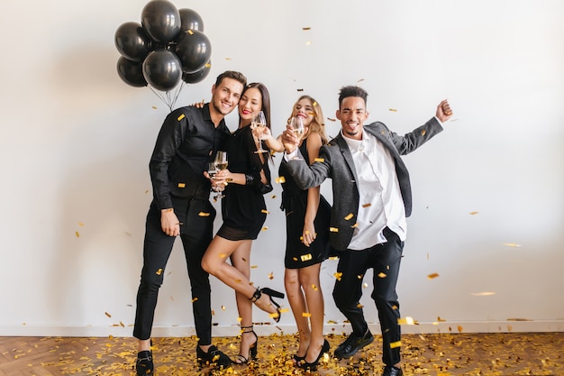 People having fun at the party with black balloons and confetti