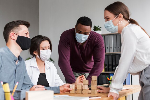 People having a meeting in the office during pandemic with masks on