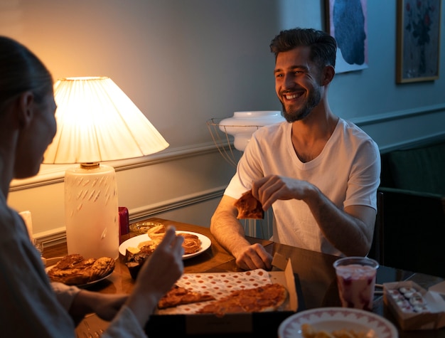 Foto gratuita persone che mangiano spuntini di notte vista laterale