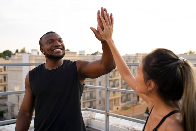 Free photo people high-fiving each other while training outdoors