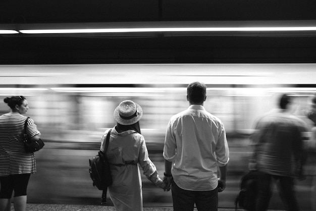 People hold each other hands standing before the underground train