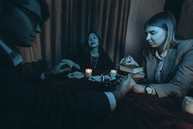 People hold hands of night at table with candles