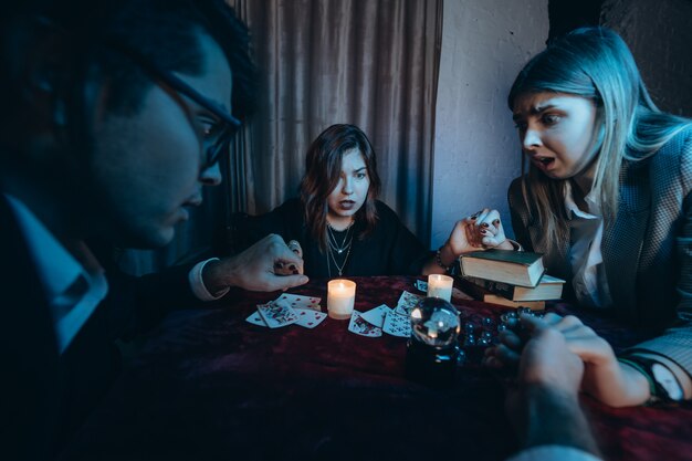 People hold hands of night at table with candles