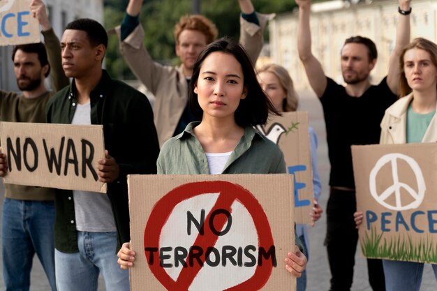 Люди с плакатами против терроризма на акции протеста